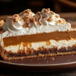 Milk Bar Pumpkin Pie topped with whipped cream and streusel on a rustic wooden table with autumn leaves.