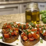 Homemade bruschetta with traditional toppings of tomatoes, garlic, and basil on a modern kitchen countertop.